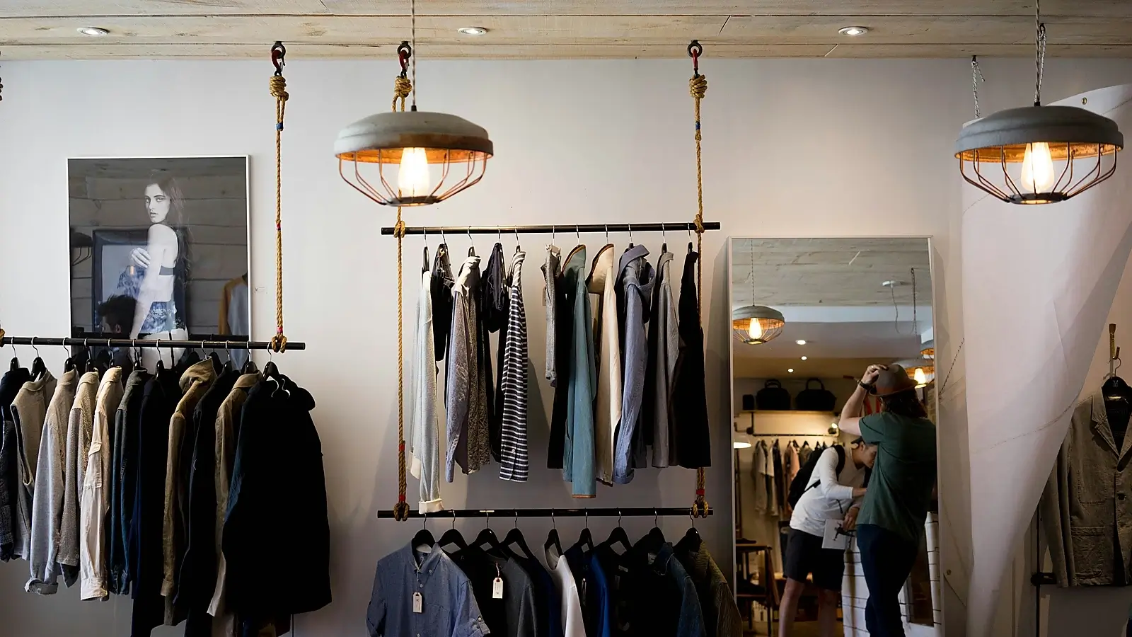 Minimal fashion boutique interior with organized clothing racks, layered apparel displays, and a modern premium retail atmosphere.