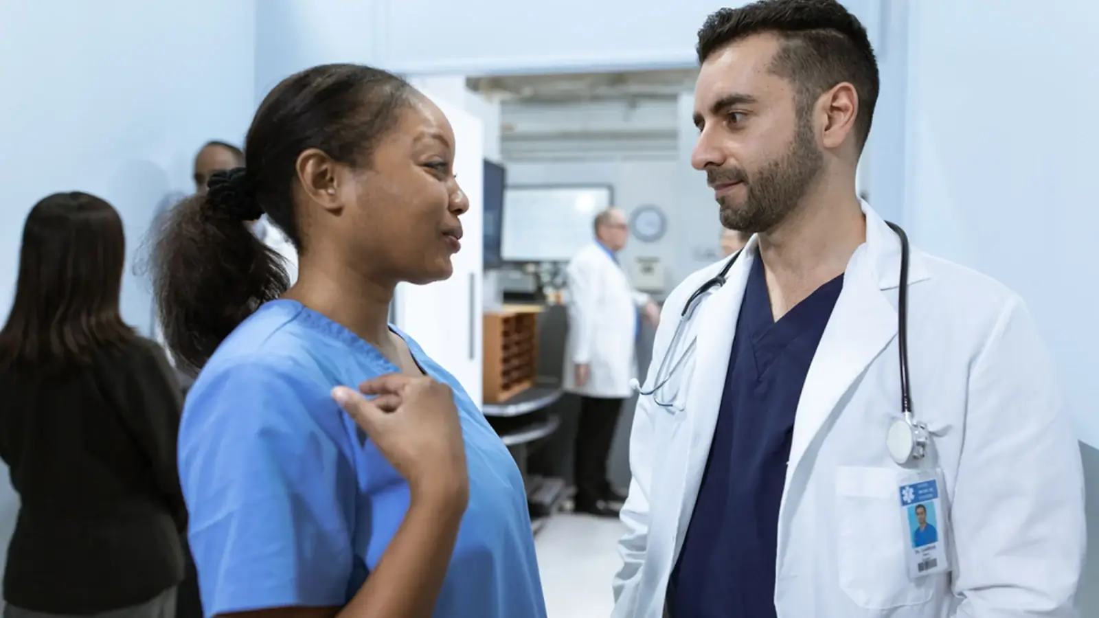 Healthcare professionals speaking in a hospital corridor, representing healthcare and medical service businesses.